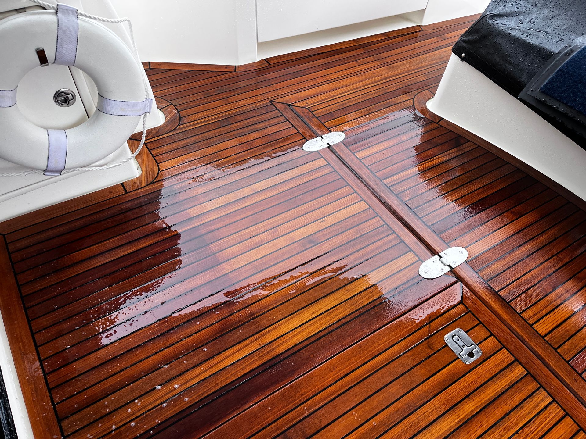 A wooden deck on a boat with a life preserver on it.