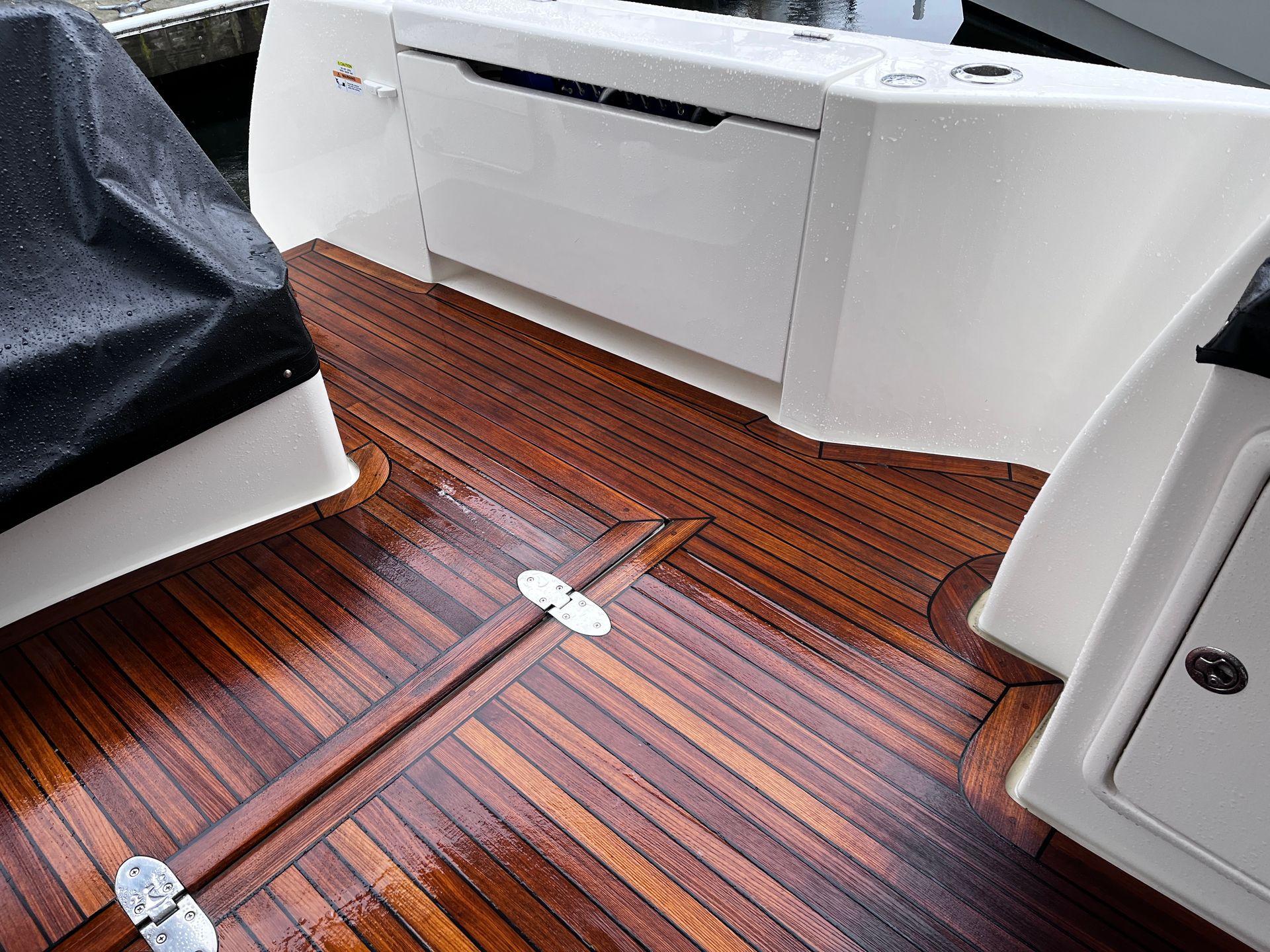 A boat with a wooden floor and a white cabinet