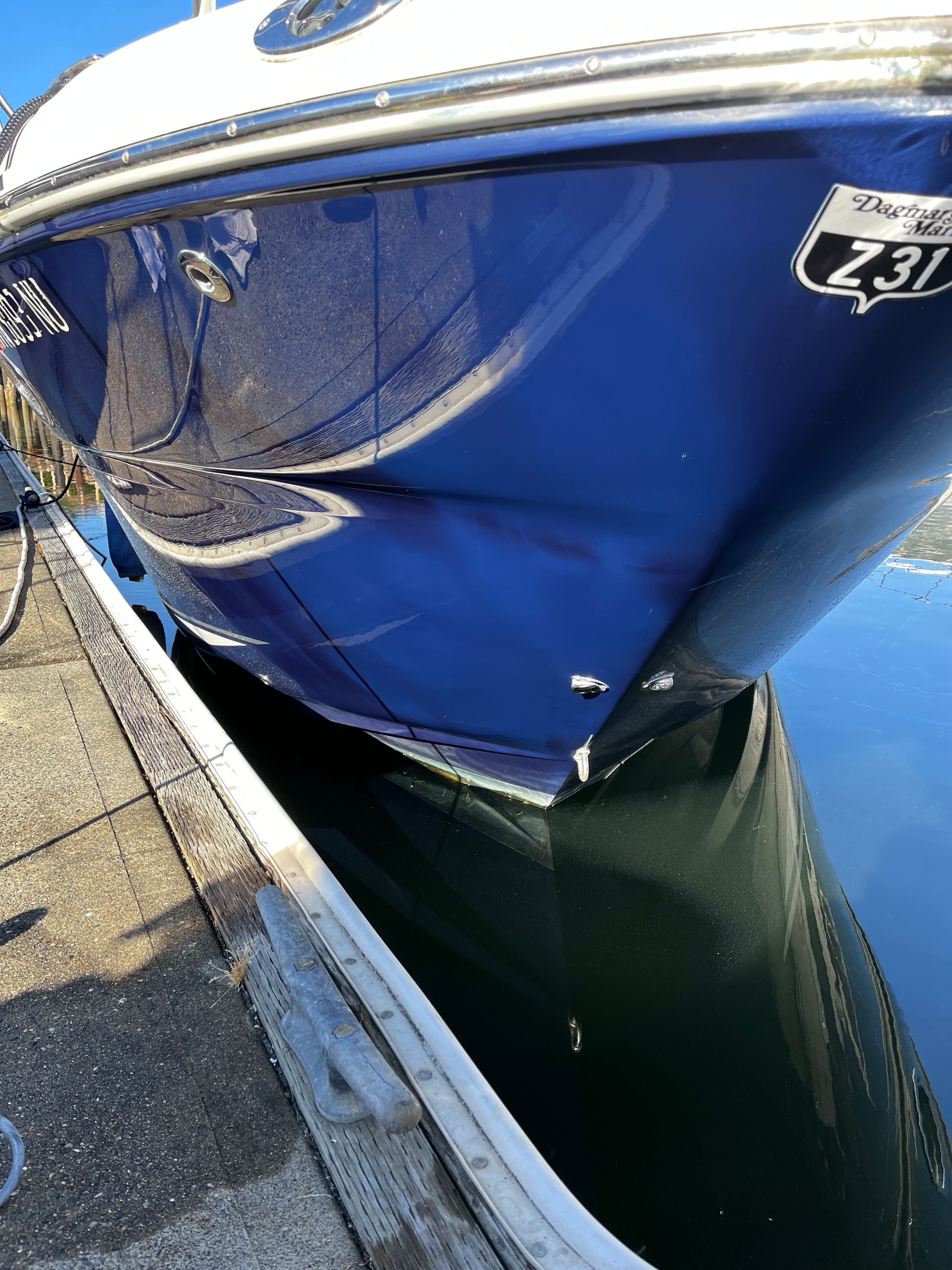 A blue and white boat is docked at a dock.