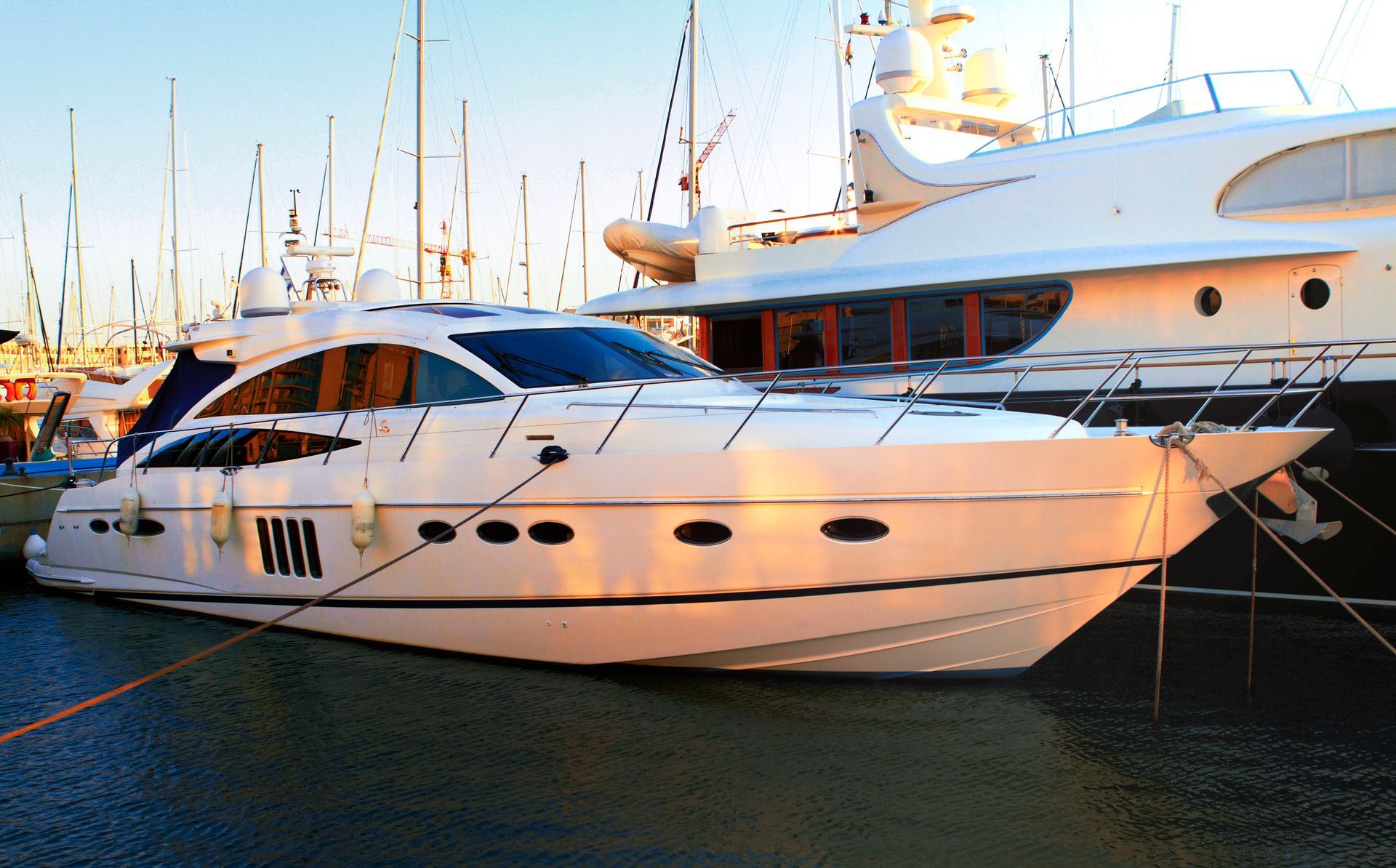 A large white yacht is docked at a marina