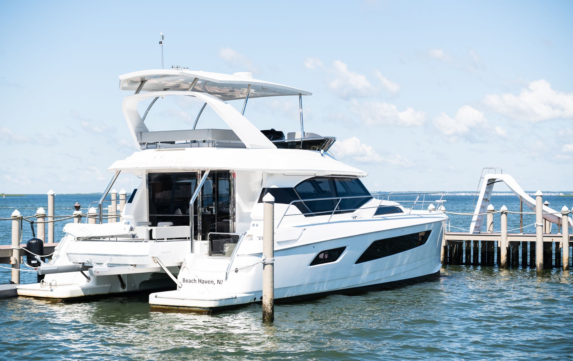 A white yacht is docked at a dock in the water.