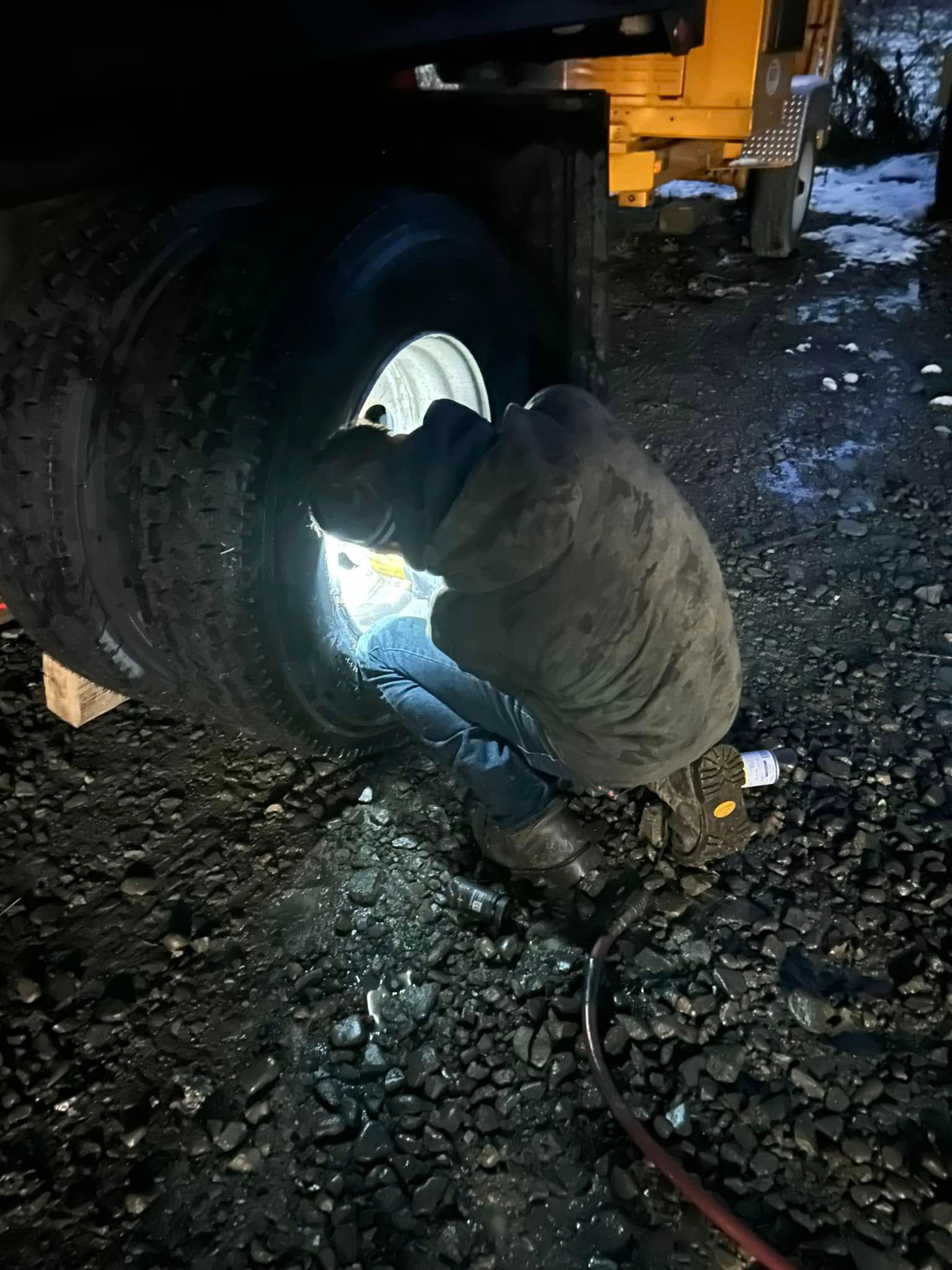 A man is welding a tire on a truck.