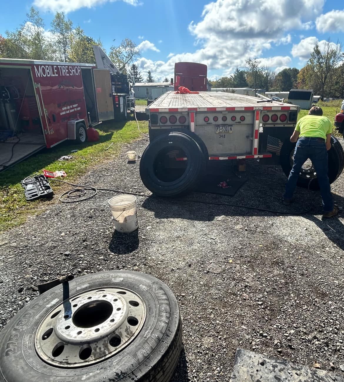 A man is changing a tire on a semi truck.