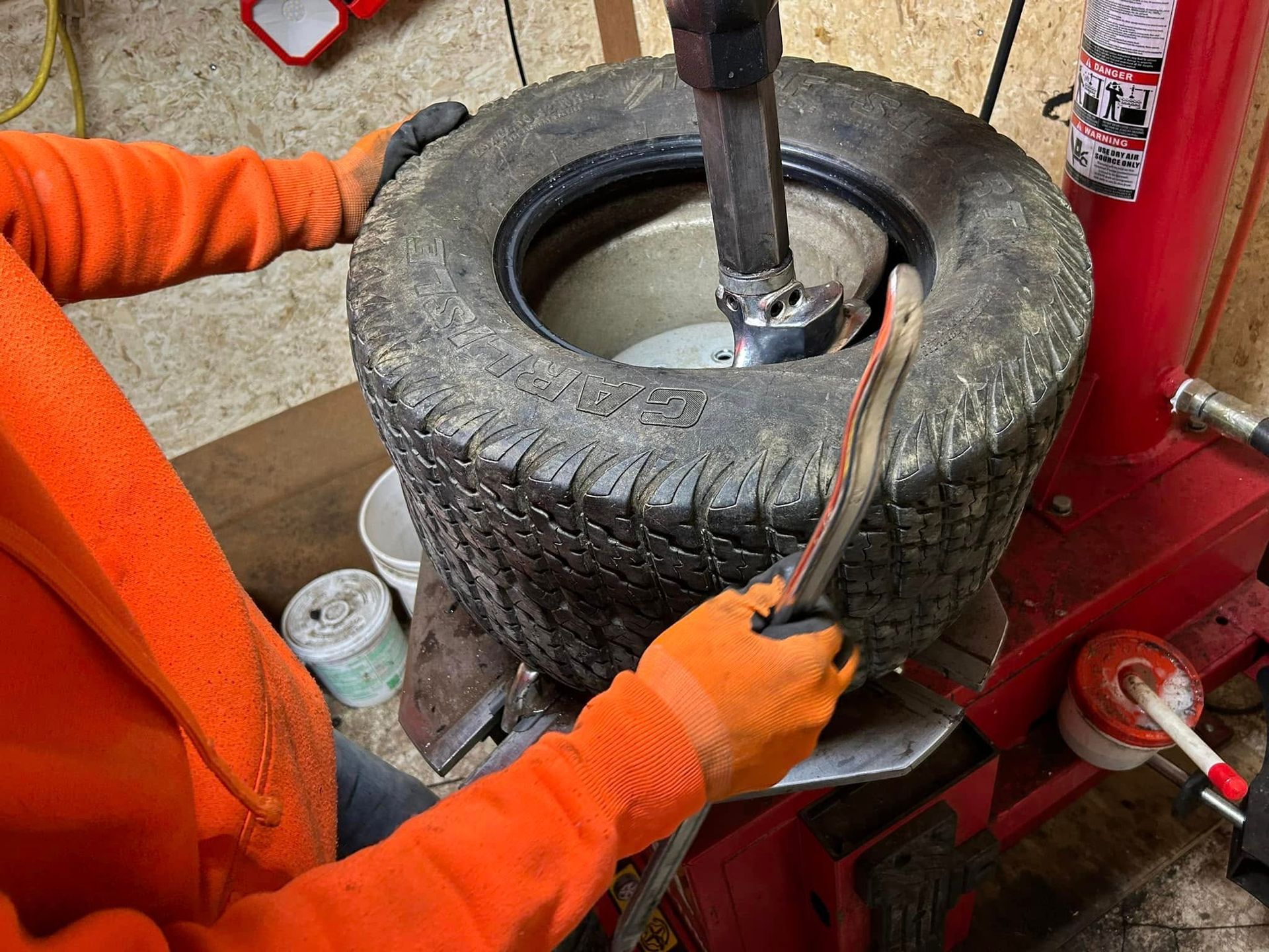 A person is changing a tire on a machine.