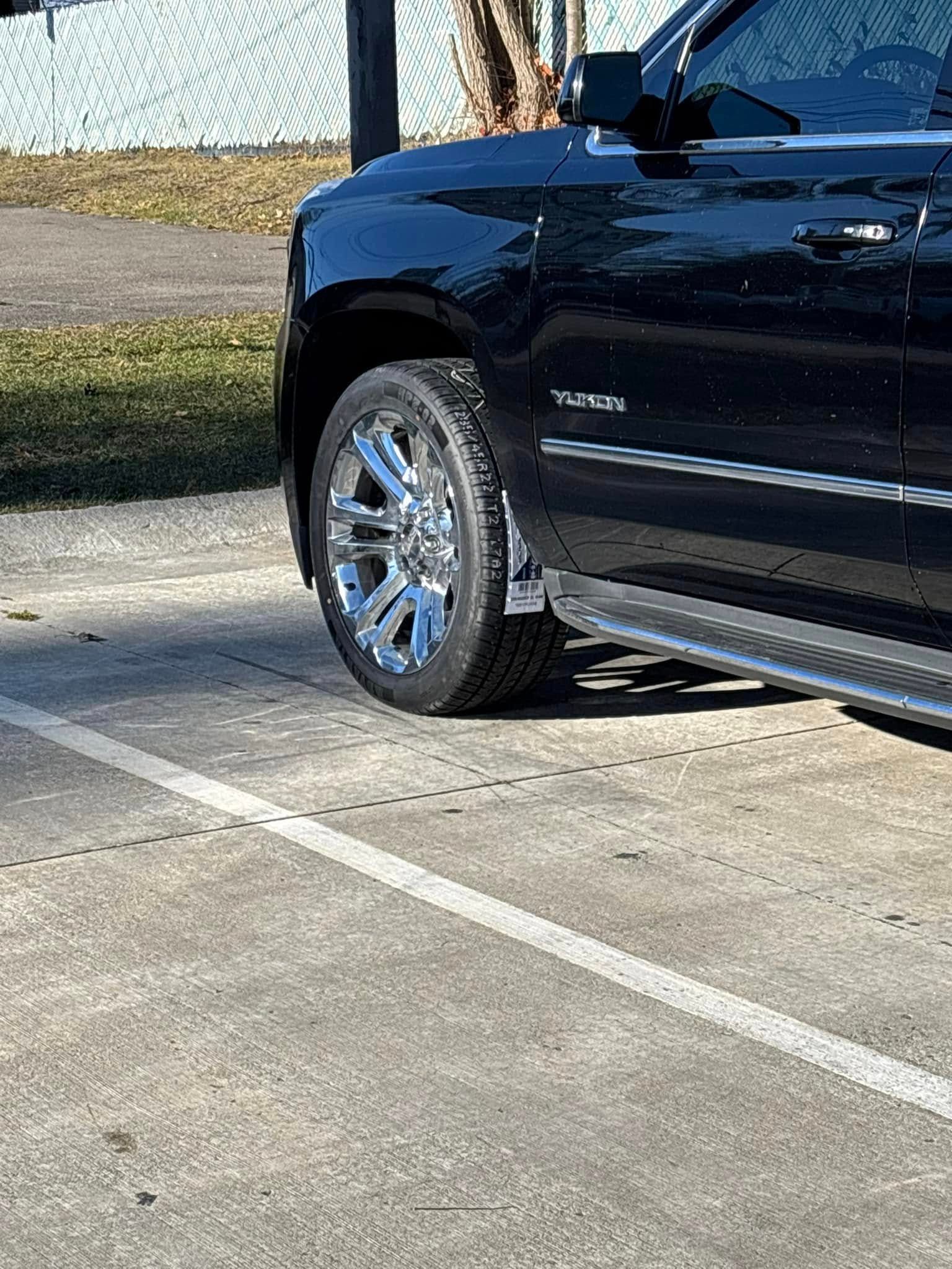 A black suv is parked in a parking lot.