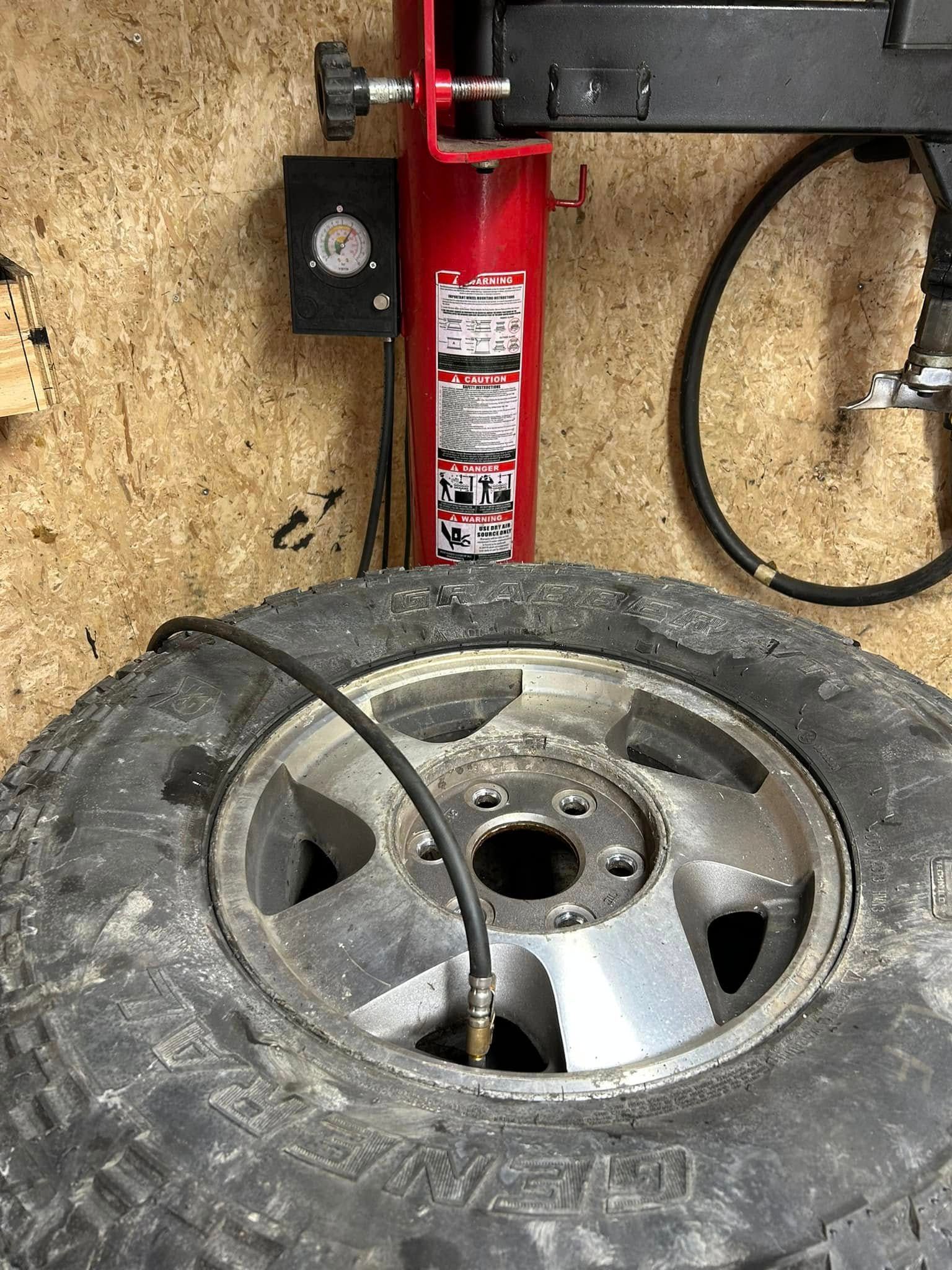 A tire is being inflated by a machine in a garage.