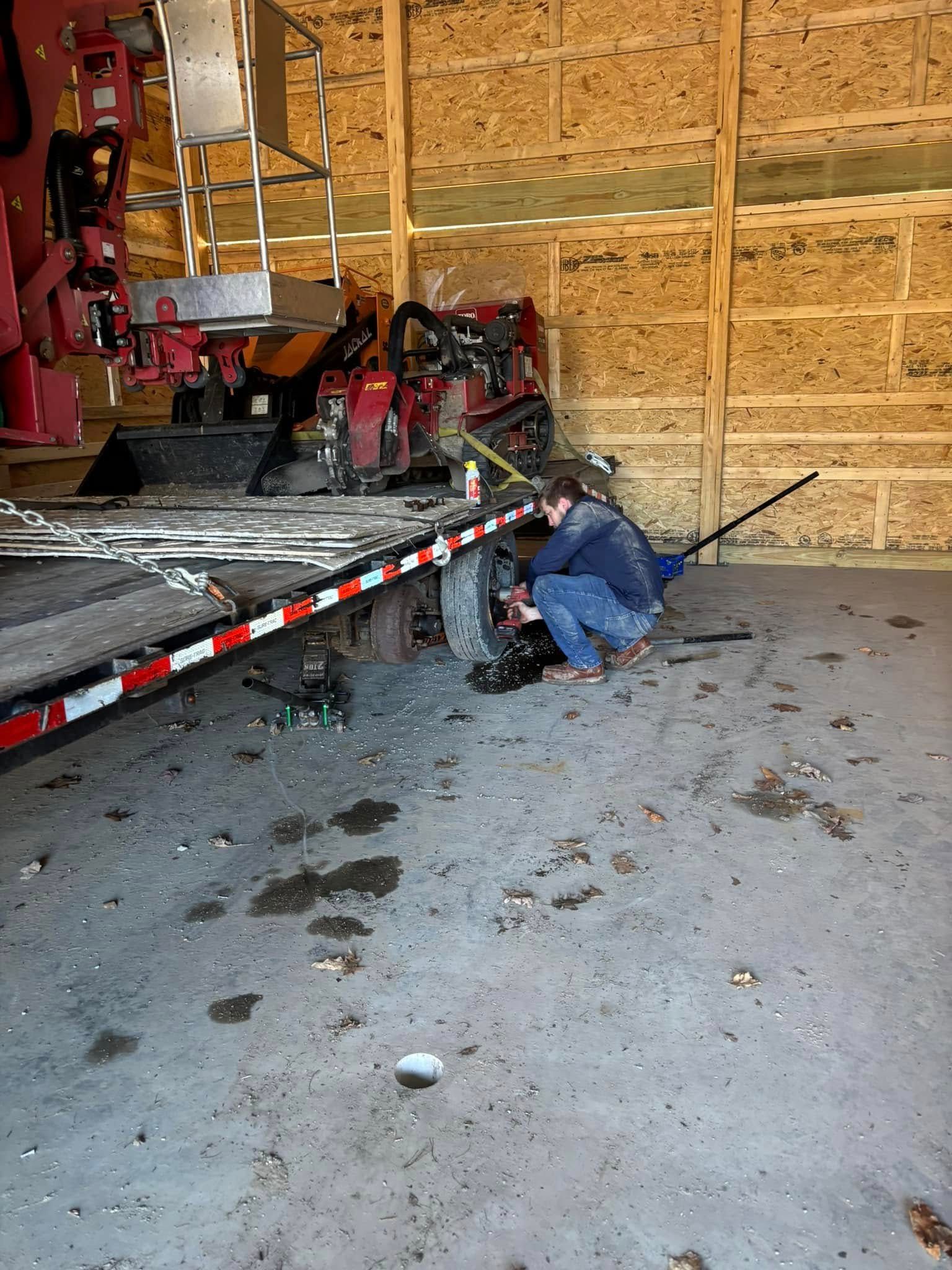 A man is working on a trailer in a garage.