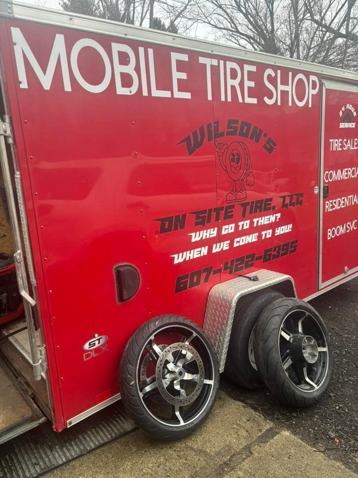 A mobile tire shop trailer with tires and wheels on it.