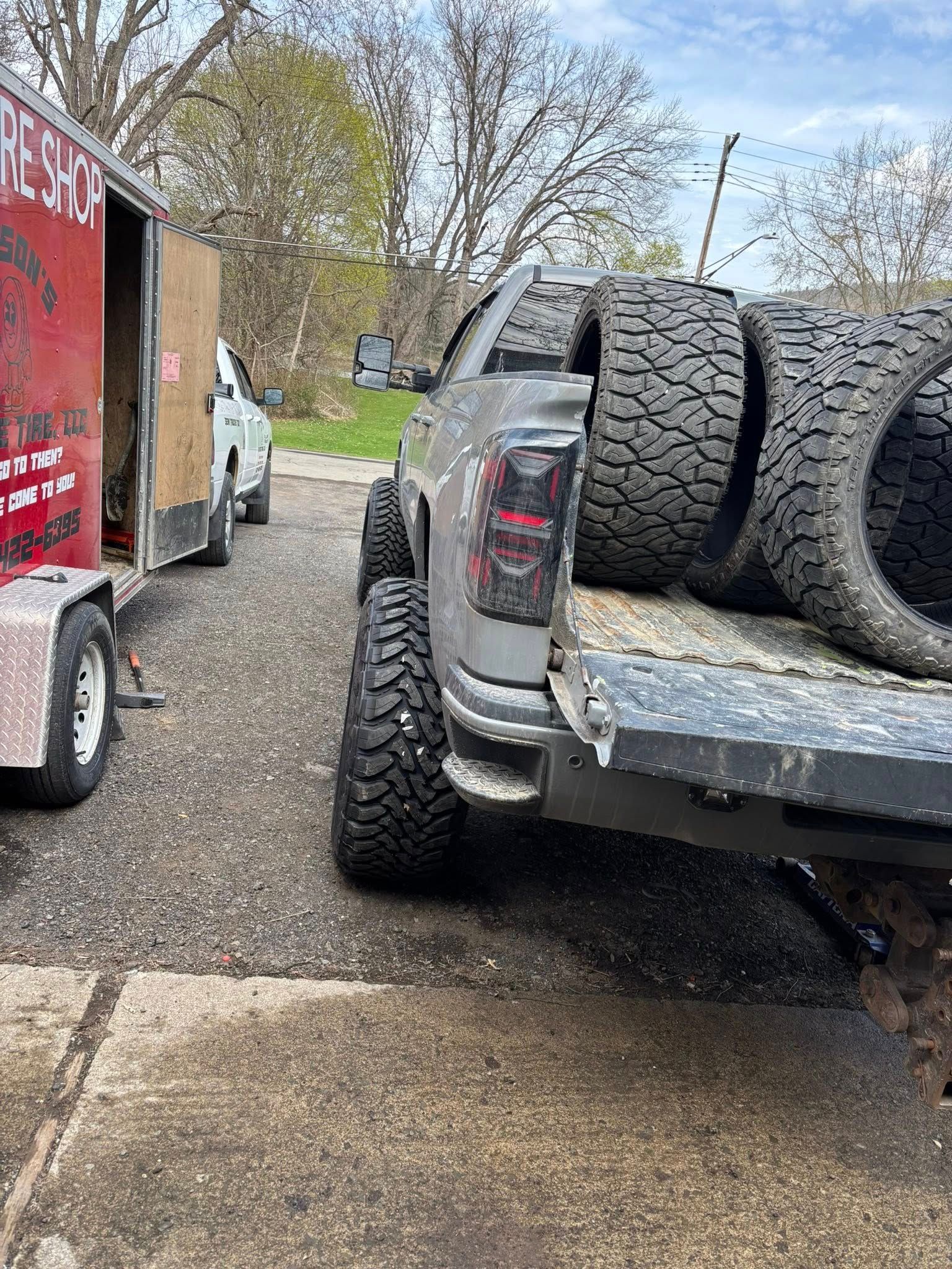 A truck is towing a trailer full of tires.
