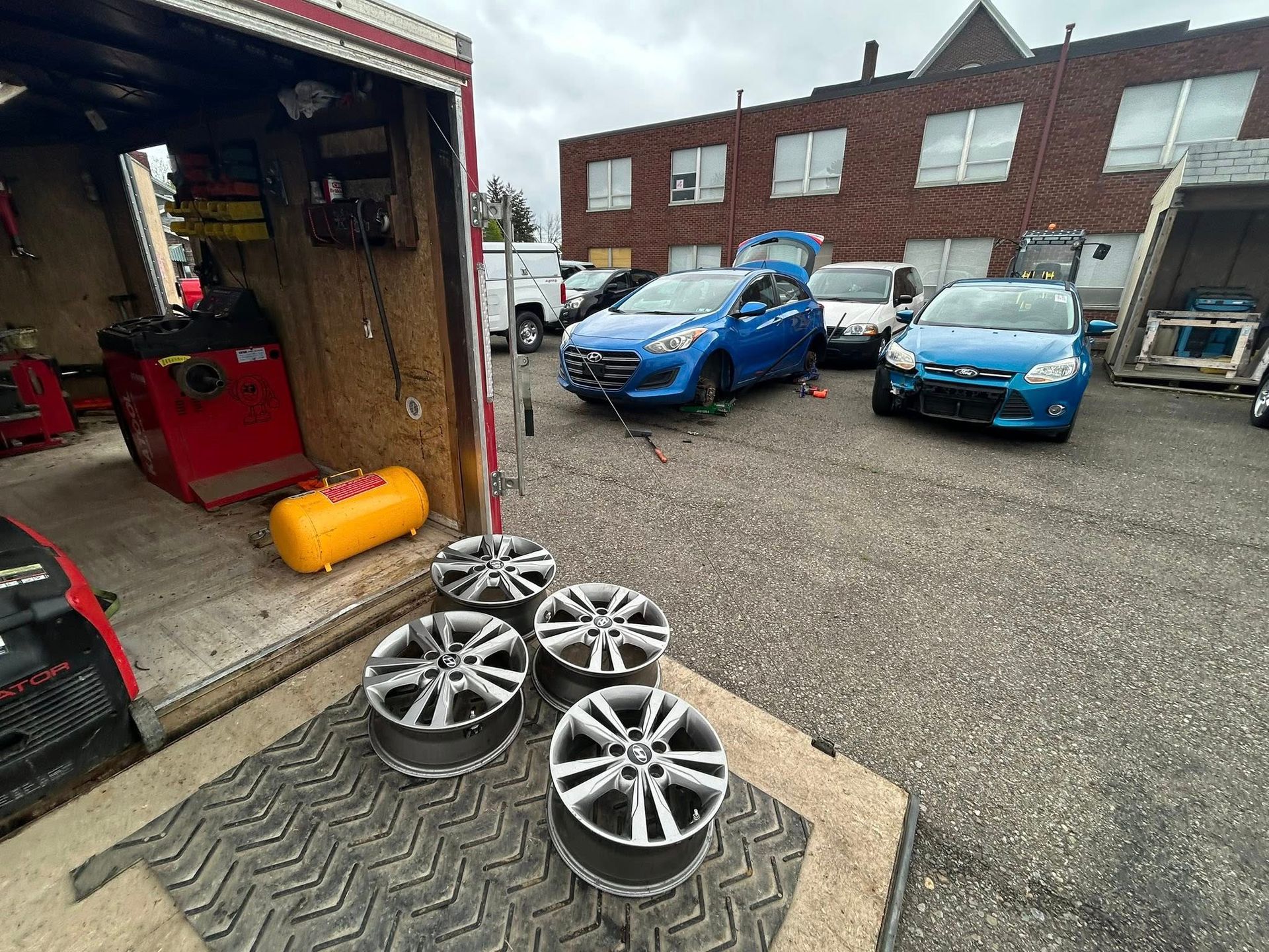 A group of cars are parked in a parking lot next to a truck.