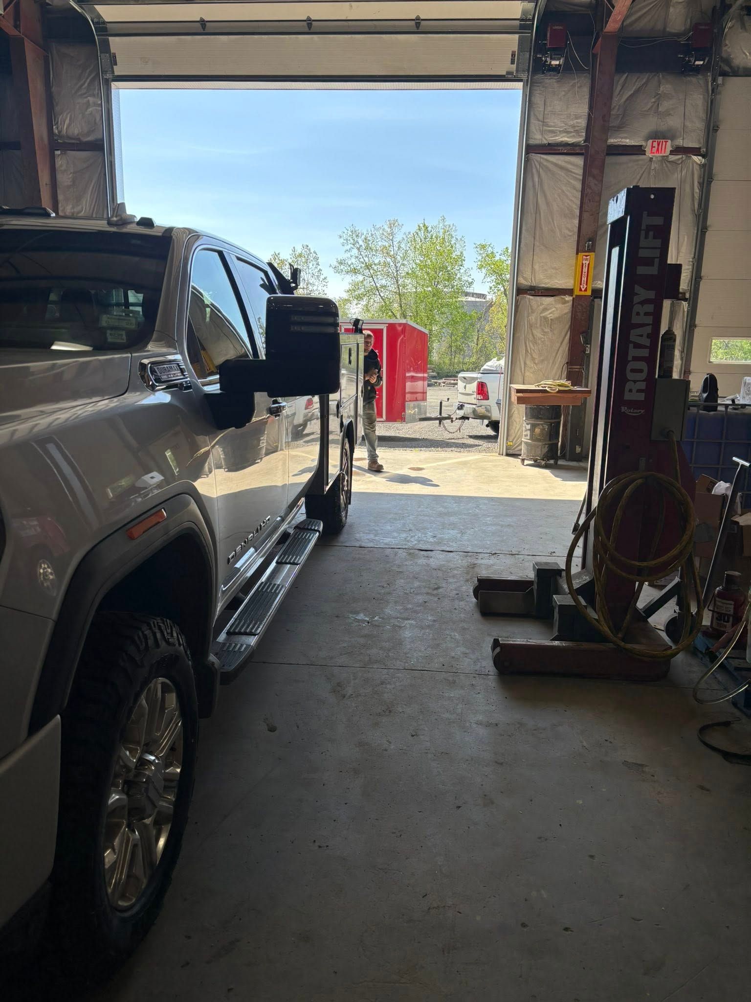 A truck is parked in a garage next to a lift.