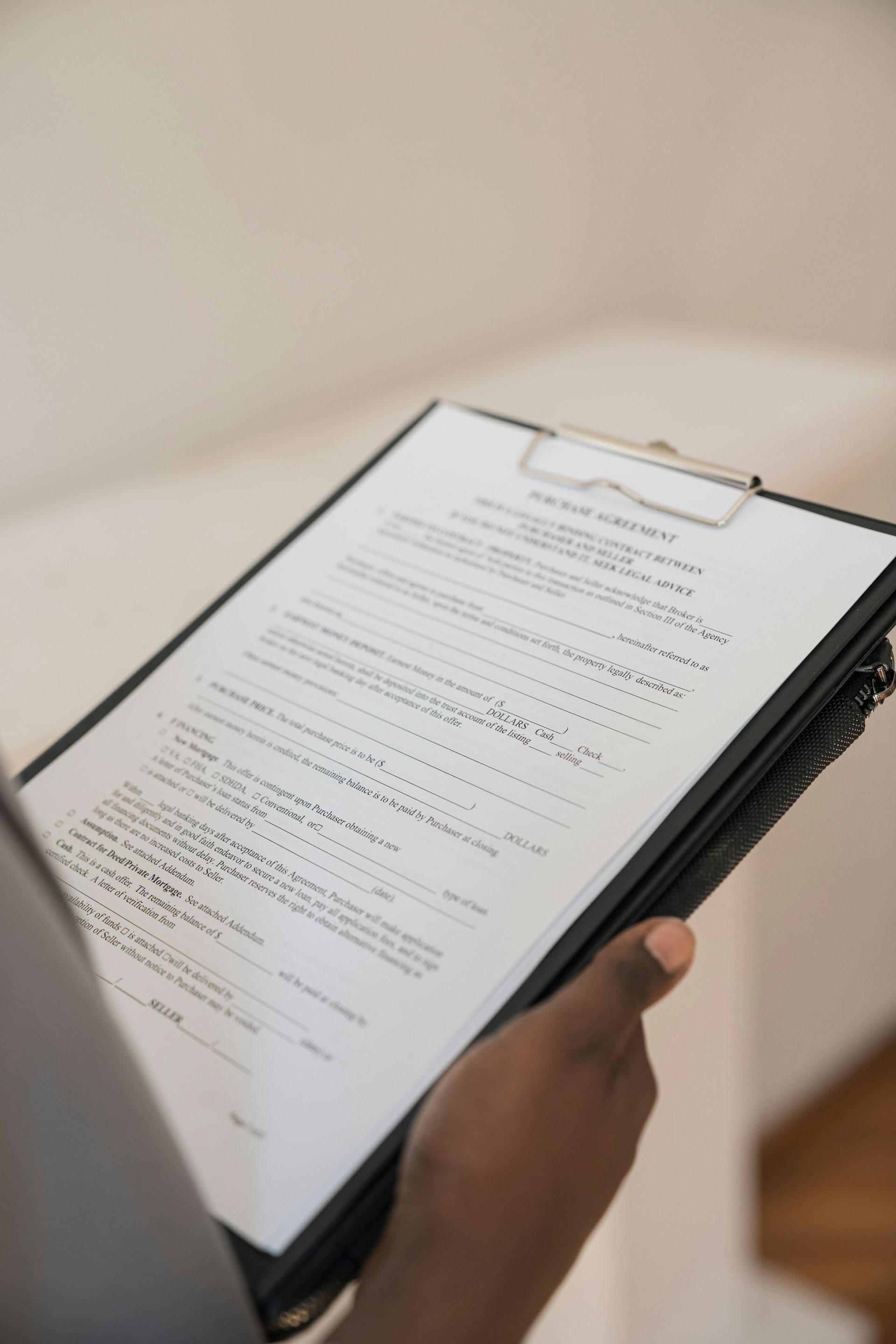 A person is holding a clipboard with a piece of paper on it.