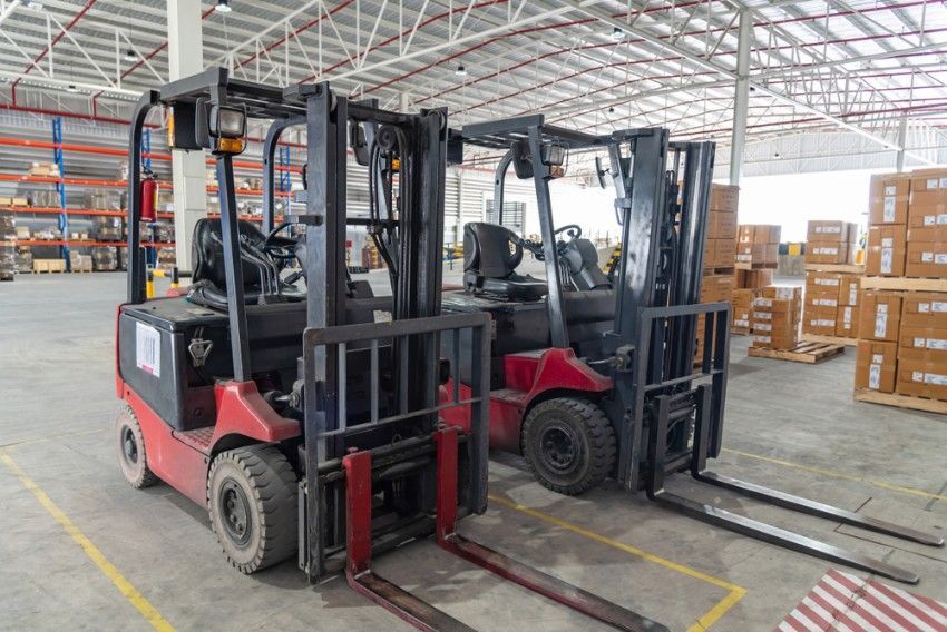 Two Forklifts Are Parked Next to Each Other in a Warehouse — Hire Power NT in Berrimah, NT