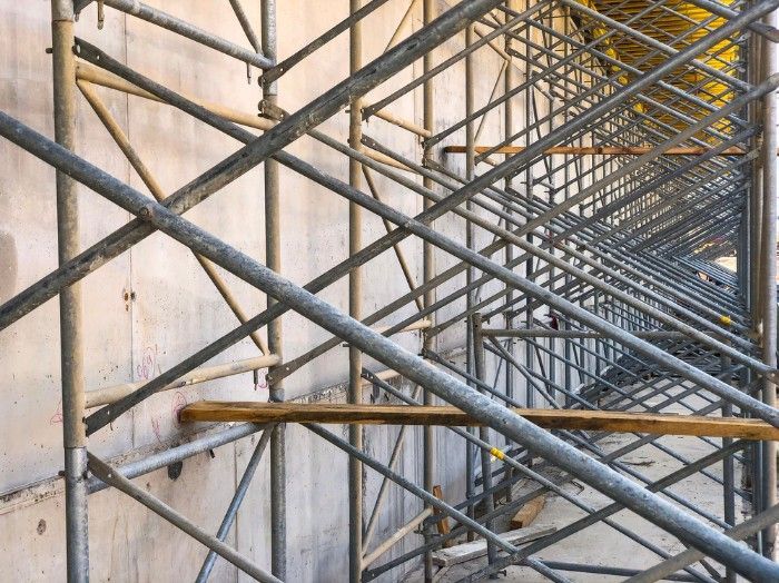 A Row of Metal Scaffolding Against a Concrete Wall — Hire Power NT in Berrimah, NT