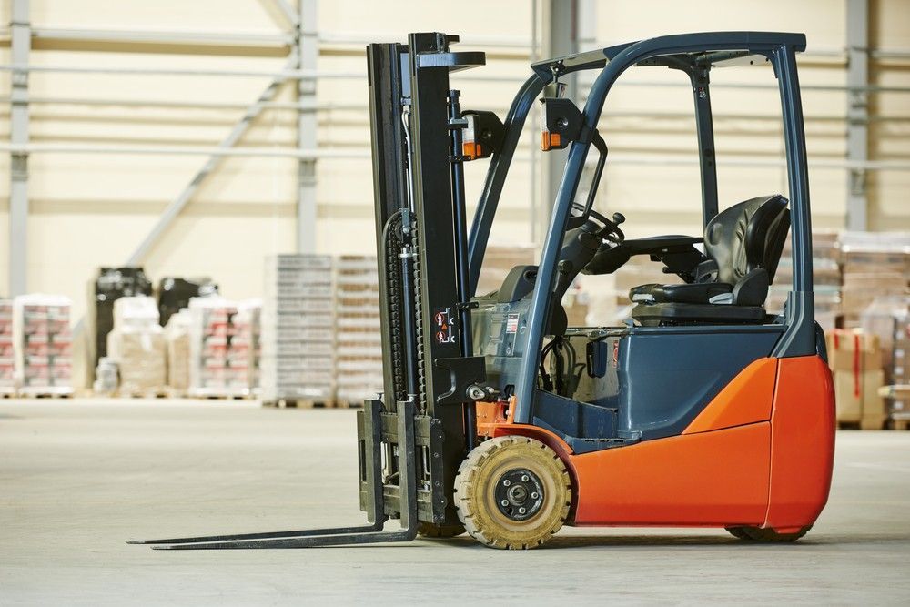 An Orange and Blue Forklift is Parked in a Warehouse — Hire Power NT in Berrimah, NT