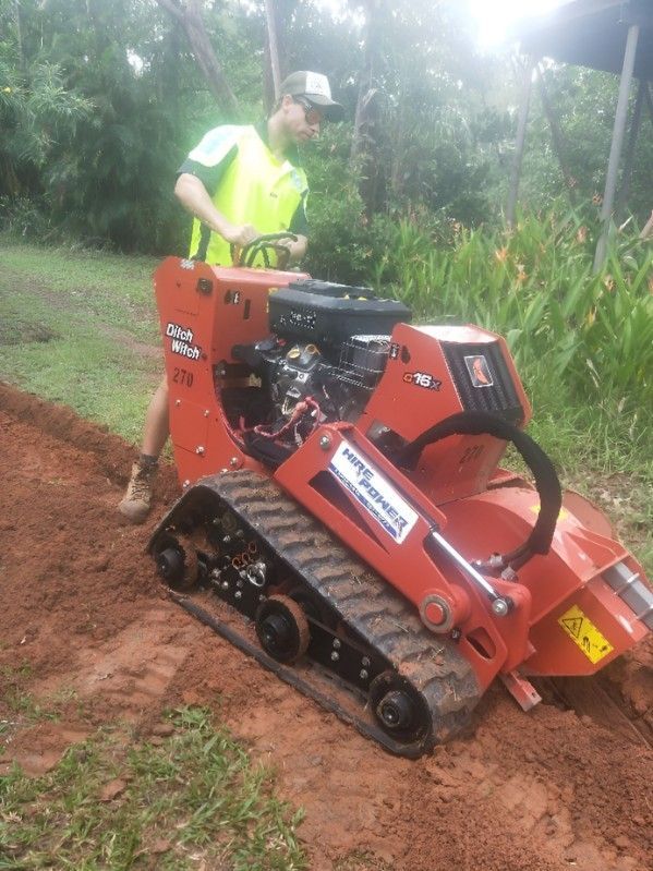 A Man is Using a Tractor to Dig a Hole in the Ground — Hire Power NT in Berrimah, NT