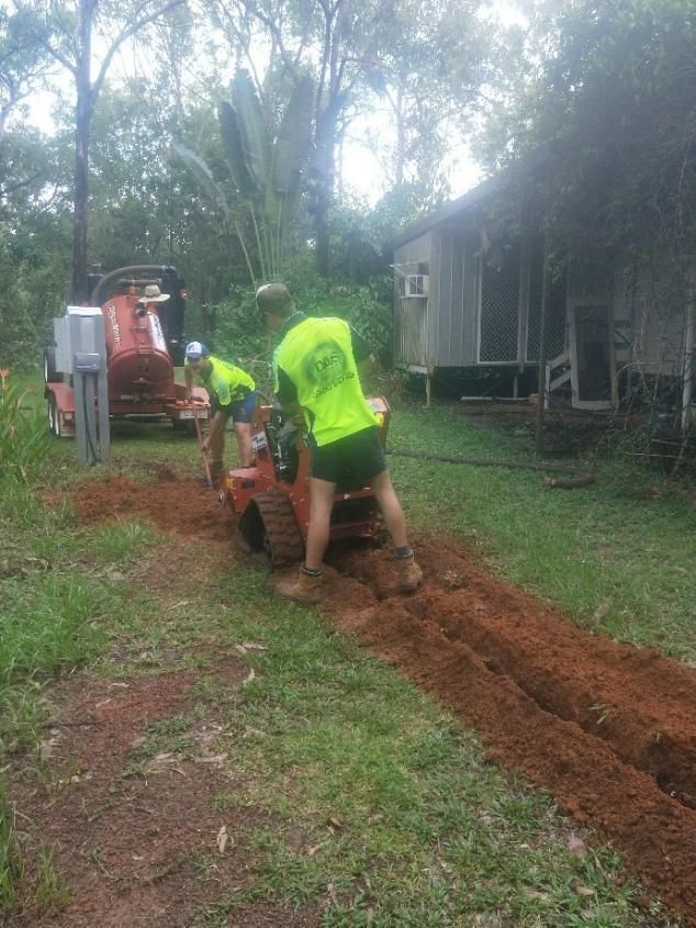 A Group of Men Are Working on a Dirt Road in Front of a House — Hire Power NT in Berrimah, NT