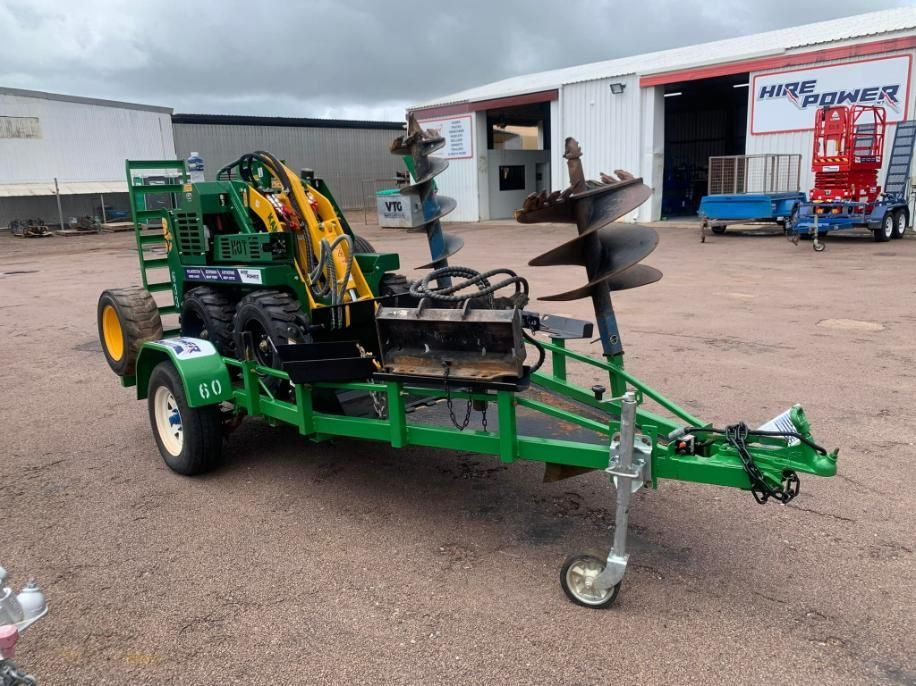 A Green Trailer With a Machine on It is Parked in Front of a Building — Hire Power NT in Berrimah, NT