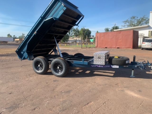 A Truck is Carrying a Trailer With a Tractor on It — Hire Power NT in Berrimah, NT