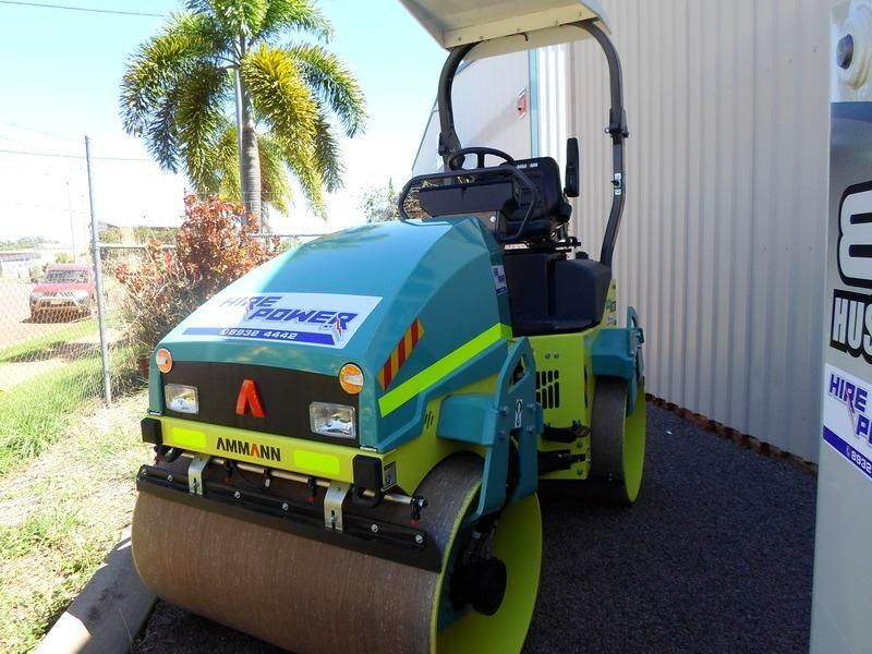 A Blue and Yellow Asphalt Roller is Parked in Front of a Building — Hire Power NT in Berrimah, NT