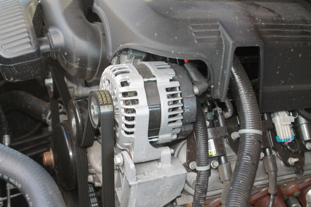 Engine compartment with an alternator and belt.