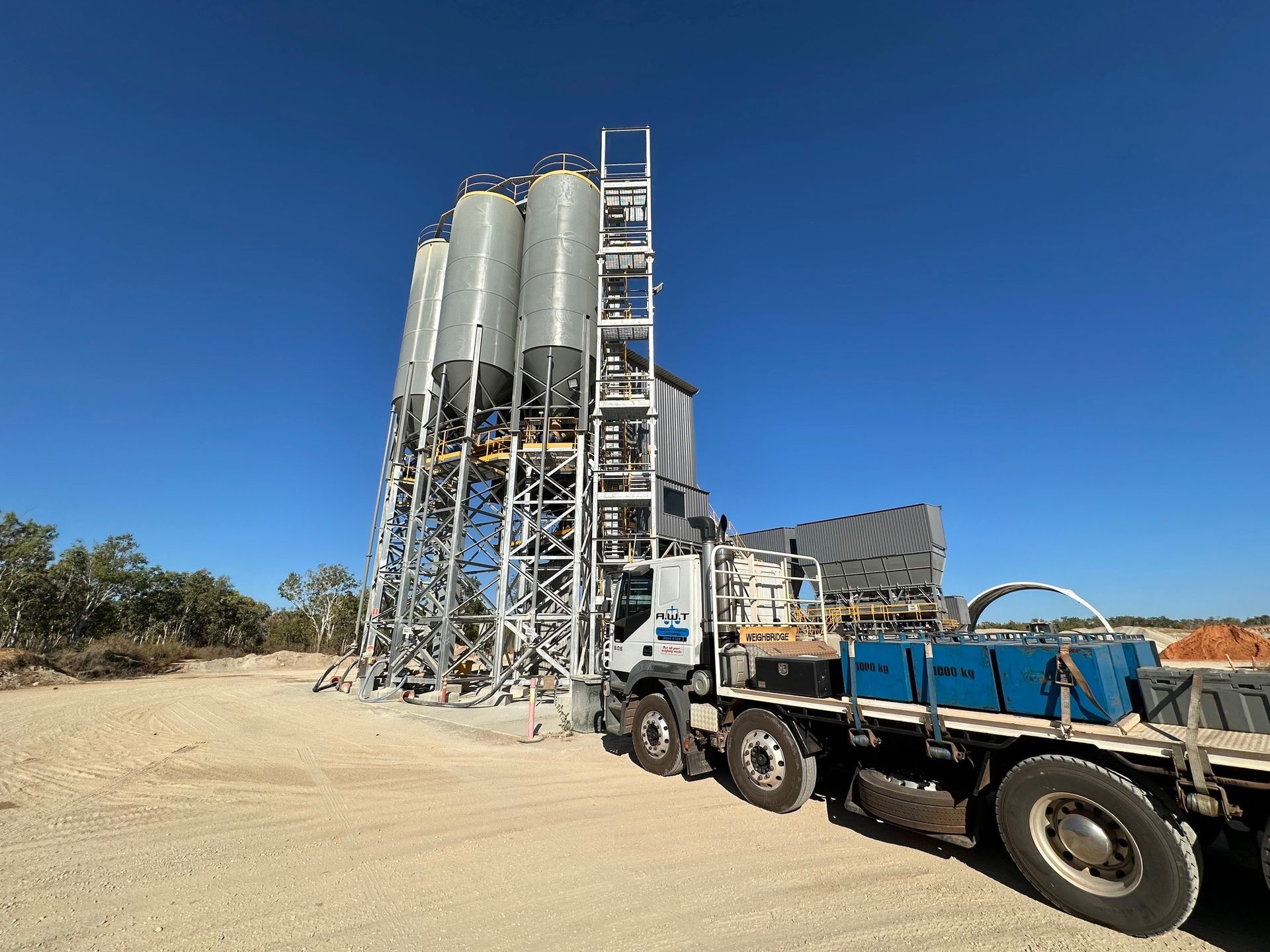 Industrial Concrete Plants and a blue truck on a sandy site under a clear blue sky — Advanced Weighing Technology NT Pty Ltd In Winnellie, NT
