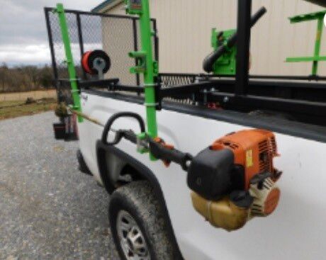 A white truck with a trimmer attached to the back