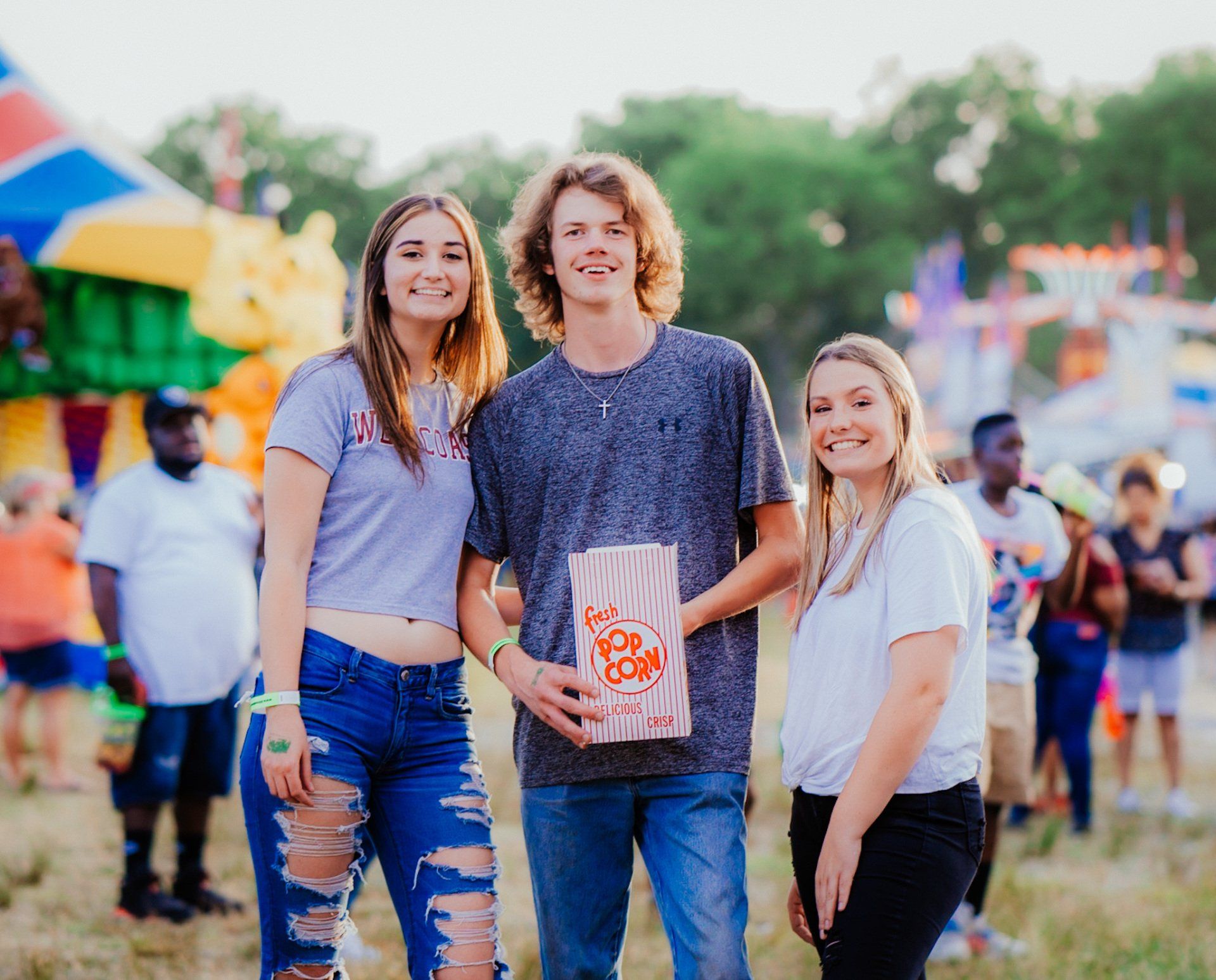 A group of young people are posing for a picture at a carnival.