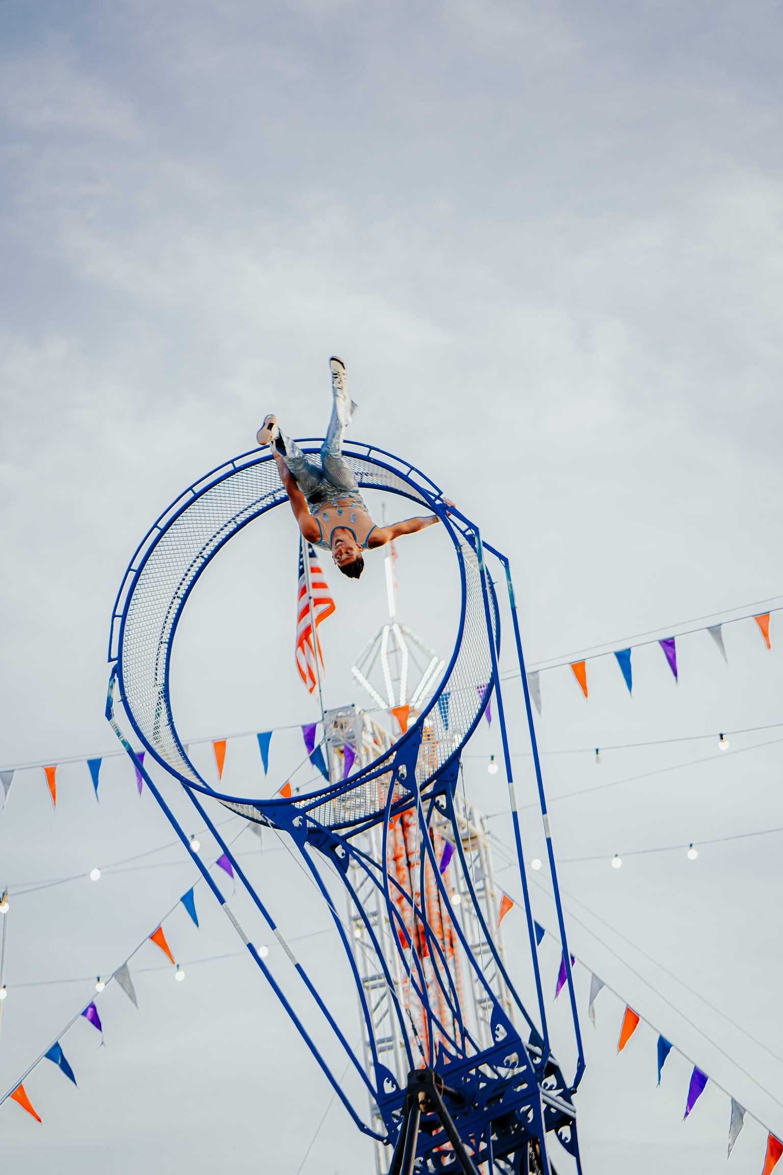 A man is doing a trick on a ferris wheel at a carnival.