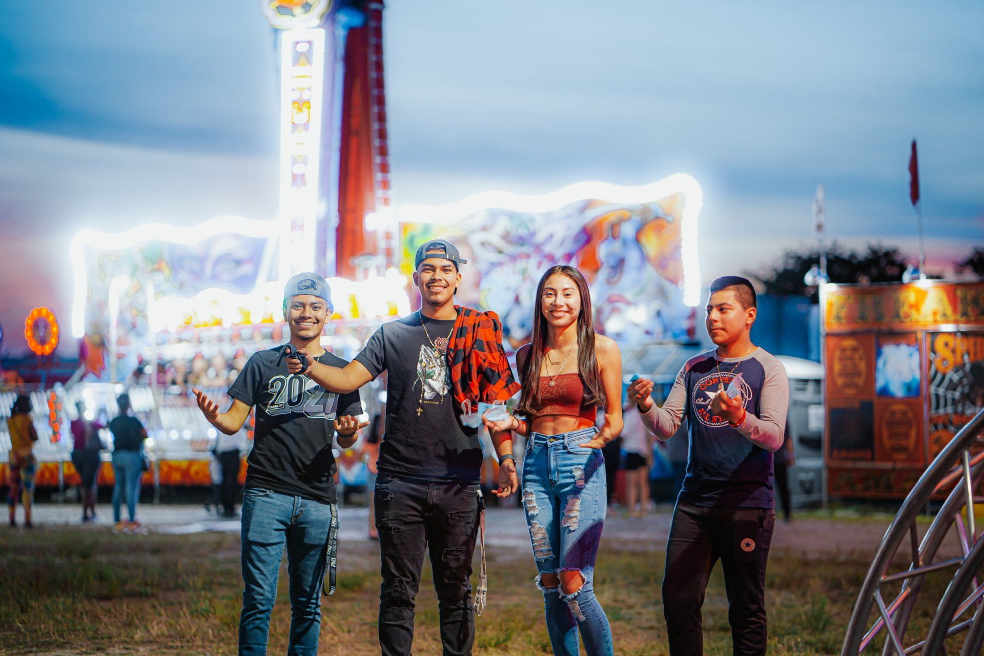 A group of people are standing in front of a carnival ride.