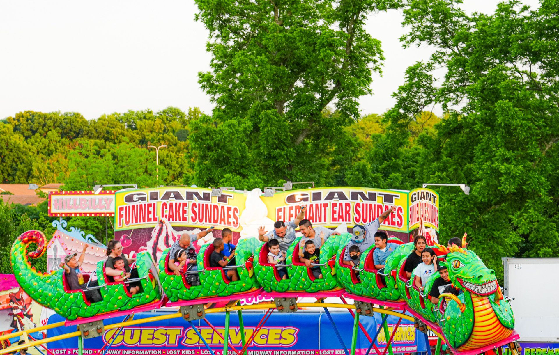 A group of people are riding a roller coaster at a carnival.