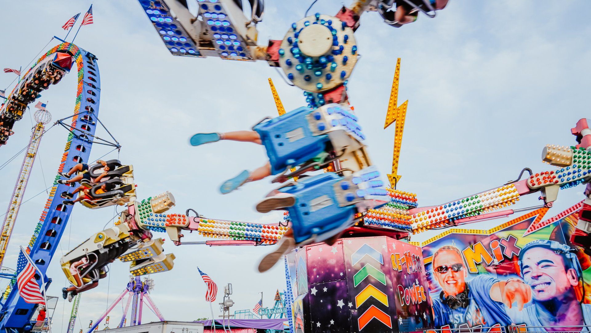 A group of people are riding a roller coaster at an amusement park.