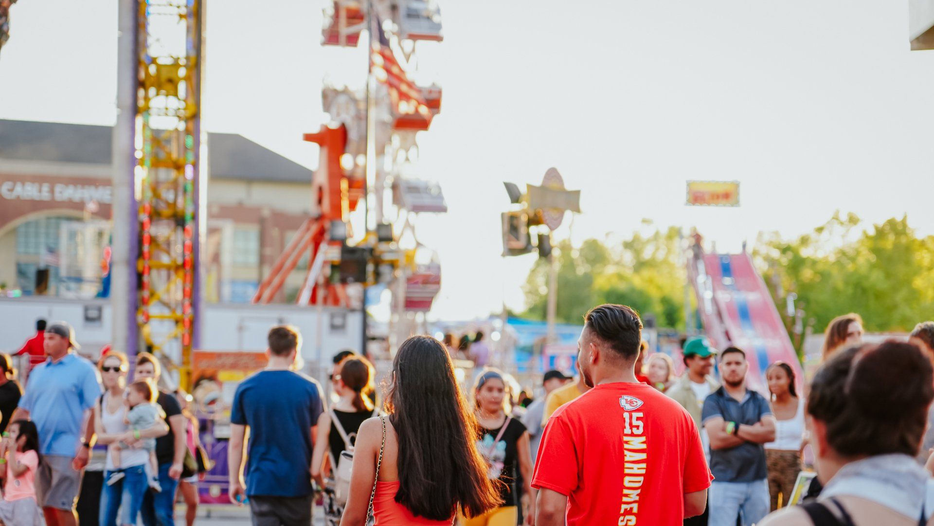 A group of people are walking down a street at a carnival.