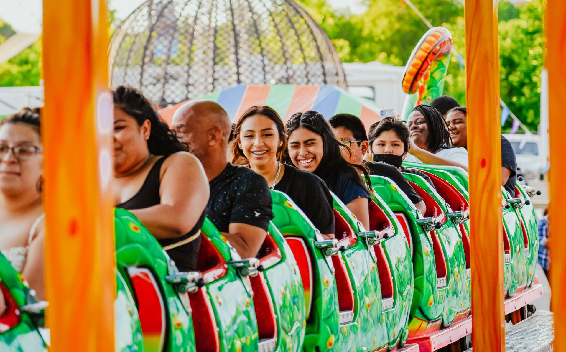 A group of people are riding a roller coaster at an amusement park.