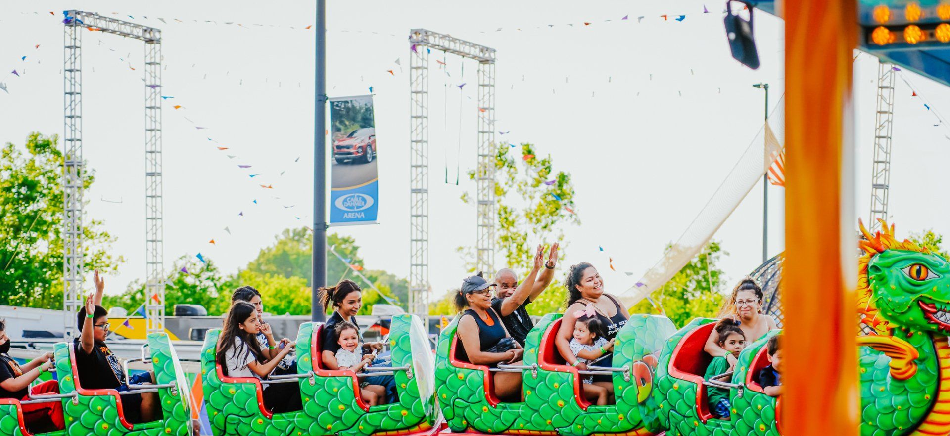 A group of people are riding a roller coaster at a carnival.