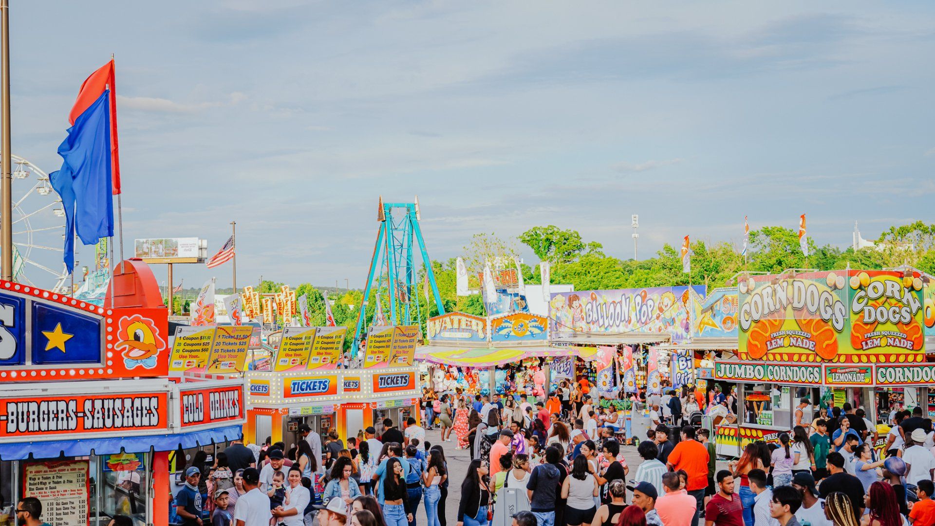 A large crowd of people are gathered at a carnival.