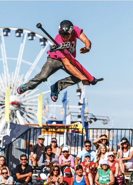 A man is doing a trick on a skateboard in front of a crowd