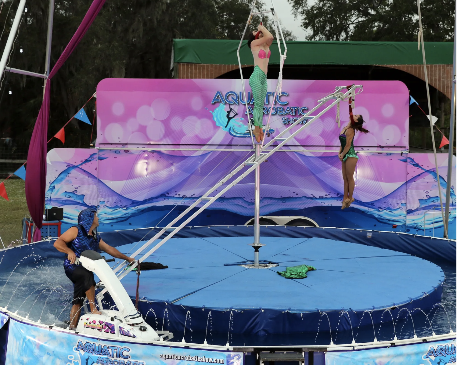 A man is riding a jet ski in front of an aquatic display