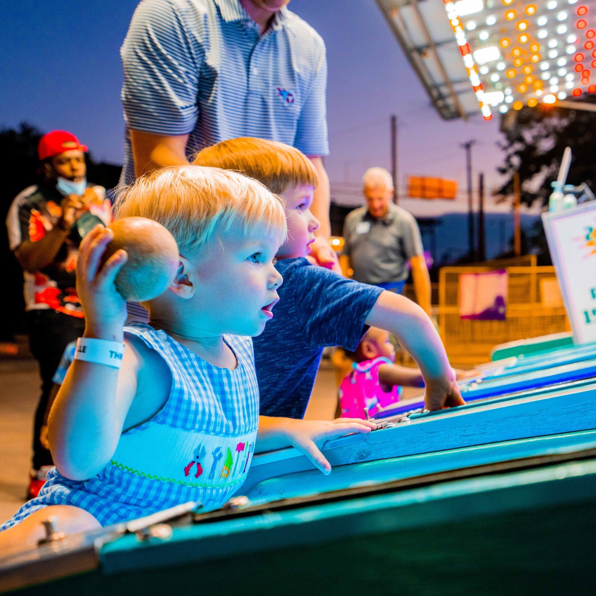 A boy and a girl are playing a game at a carnival
