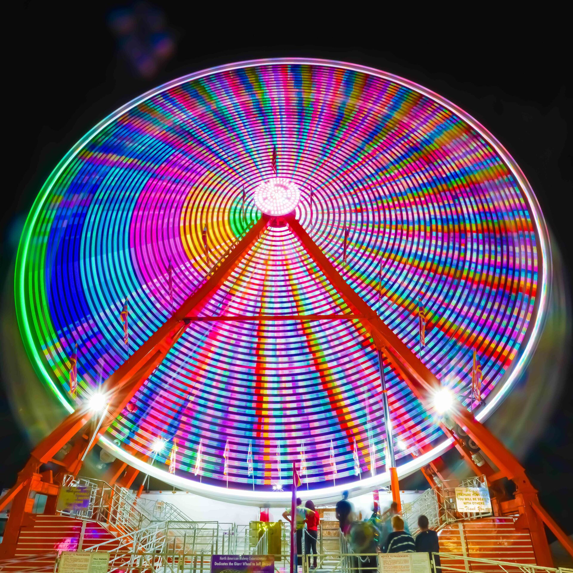 A colorful ferris wheel at a carnival at night