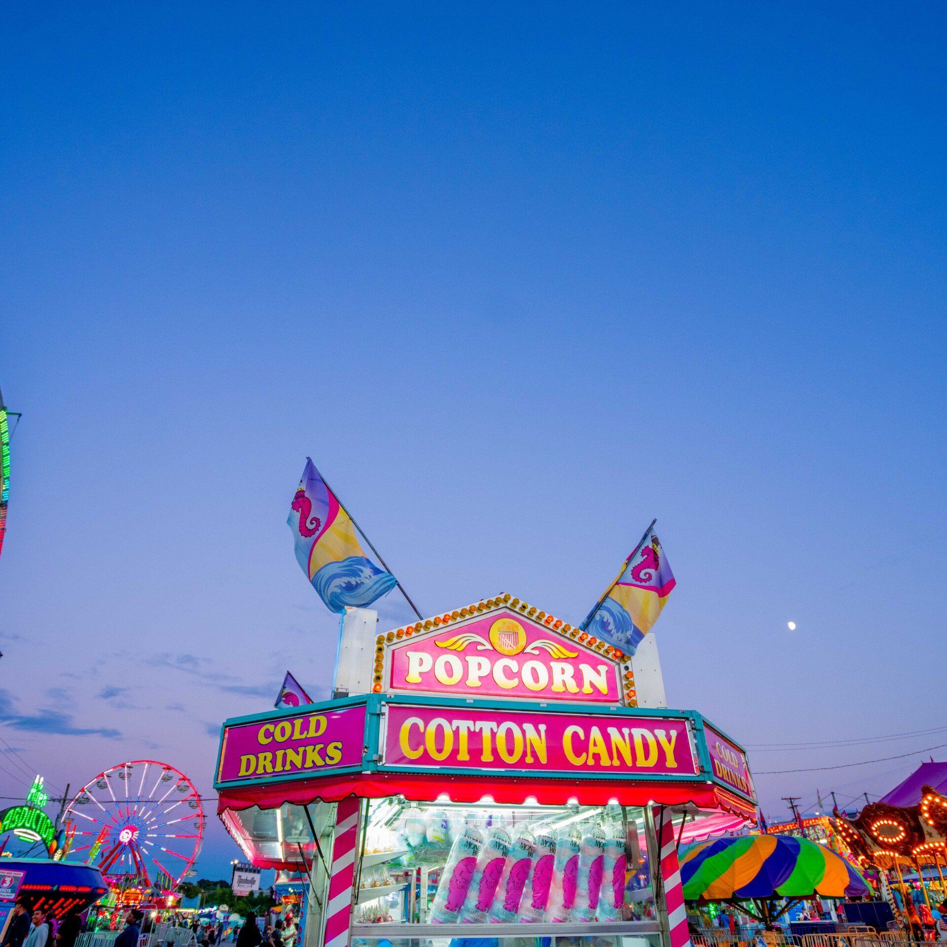 A popcorn and cotton candy stand at a carnival