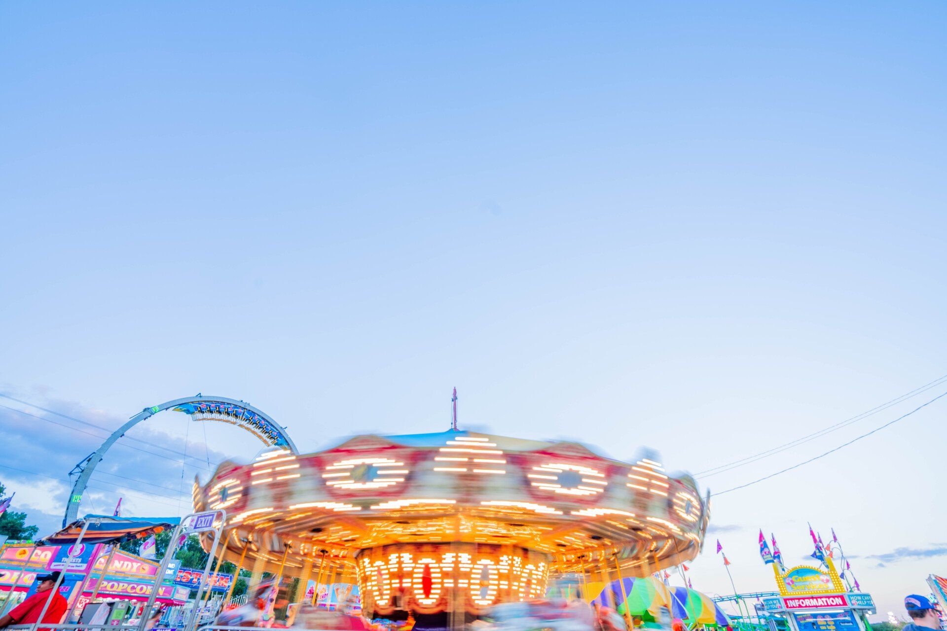 A carousel at a carnival with a blue sky in the background.