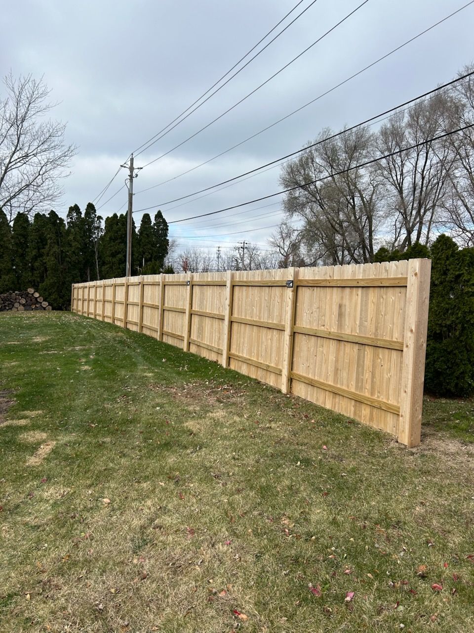 A wooden fence is sitting in the middle of a grassy field.