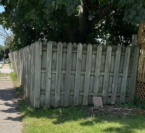 A wooden fence with a tree in the background