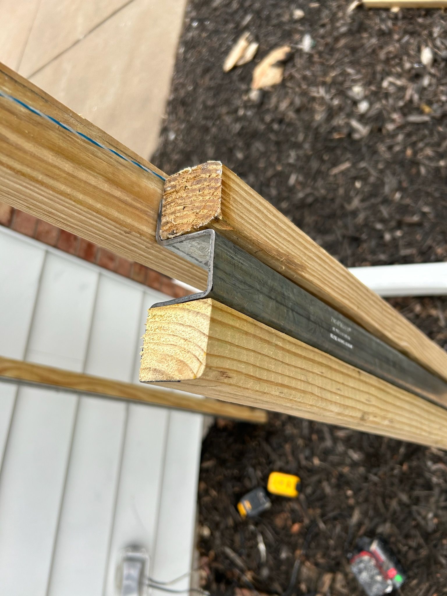 A close up of a piece of wood with a metal bar attached to it.