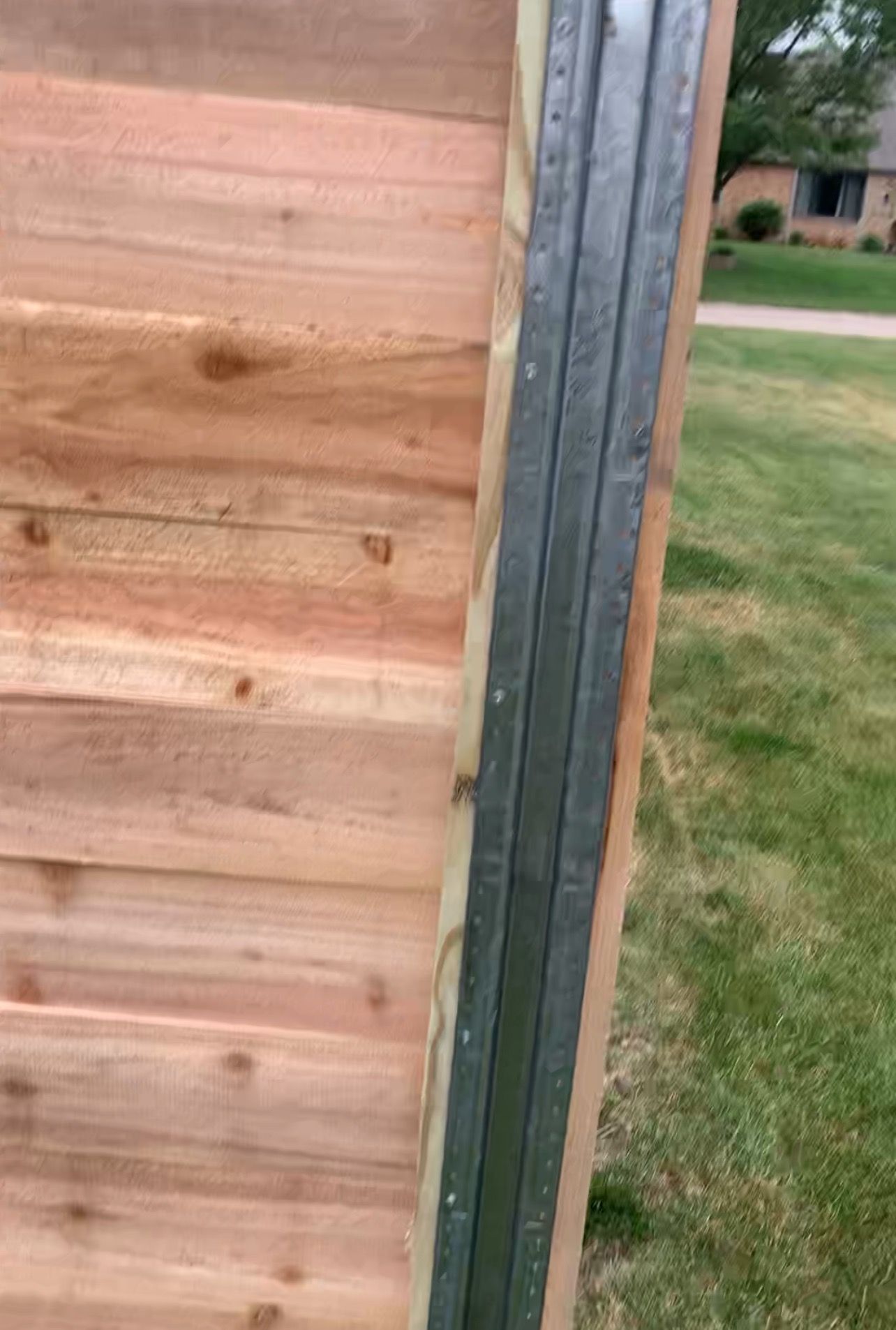A close up of a wooden fence with a metal frame.