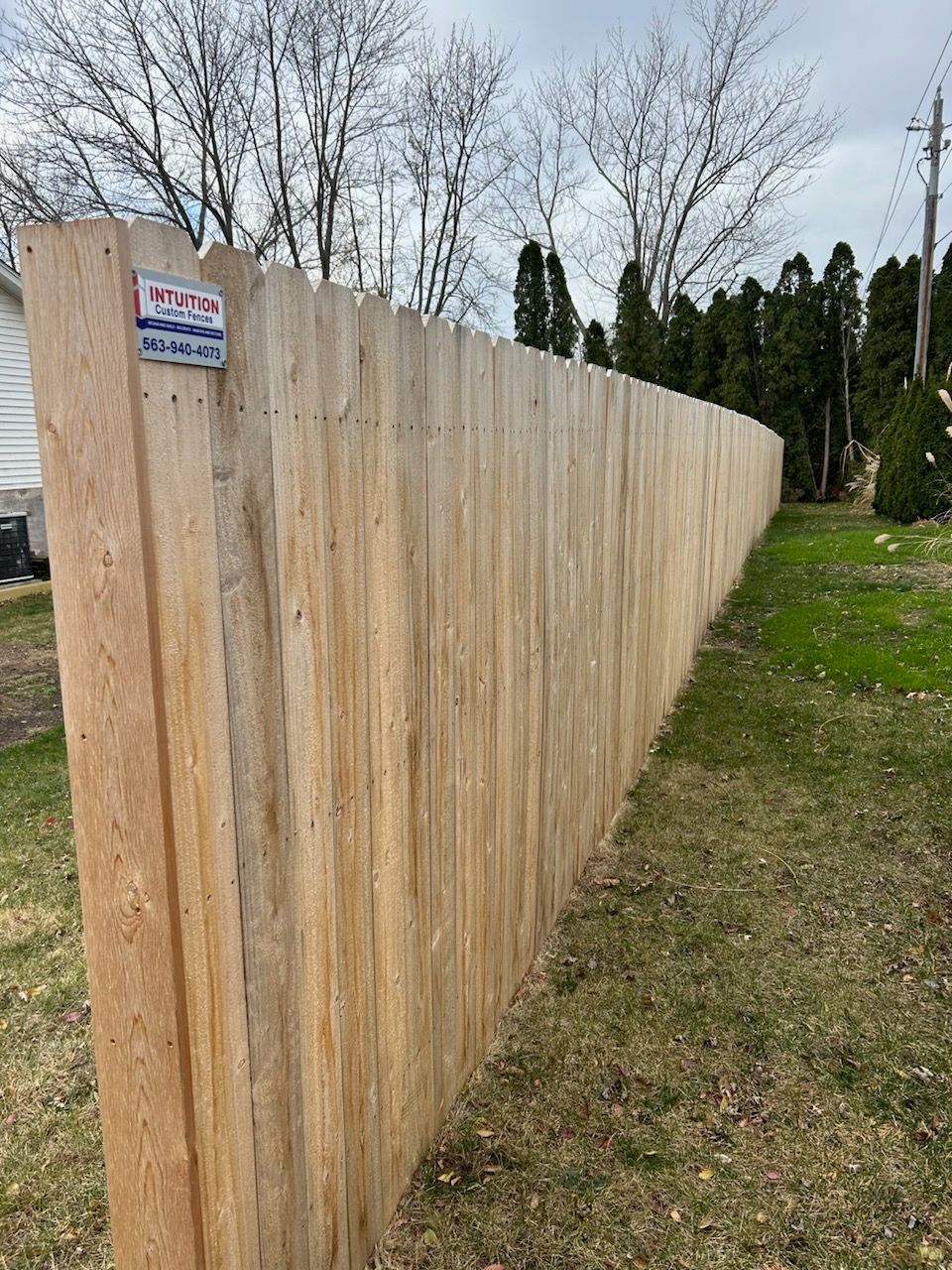 A wooden fence is sitting in the middle of a grassy field.