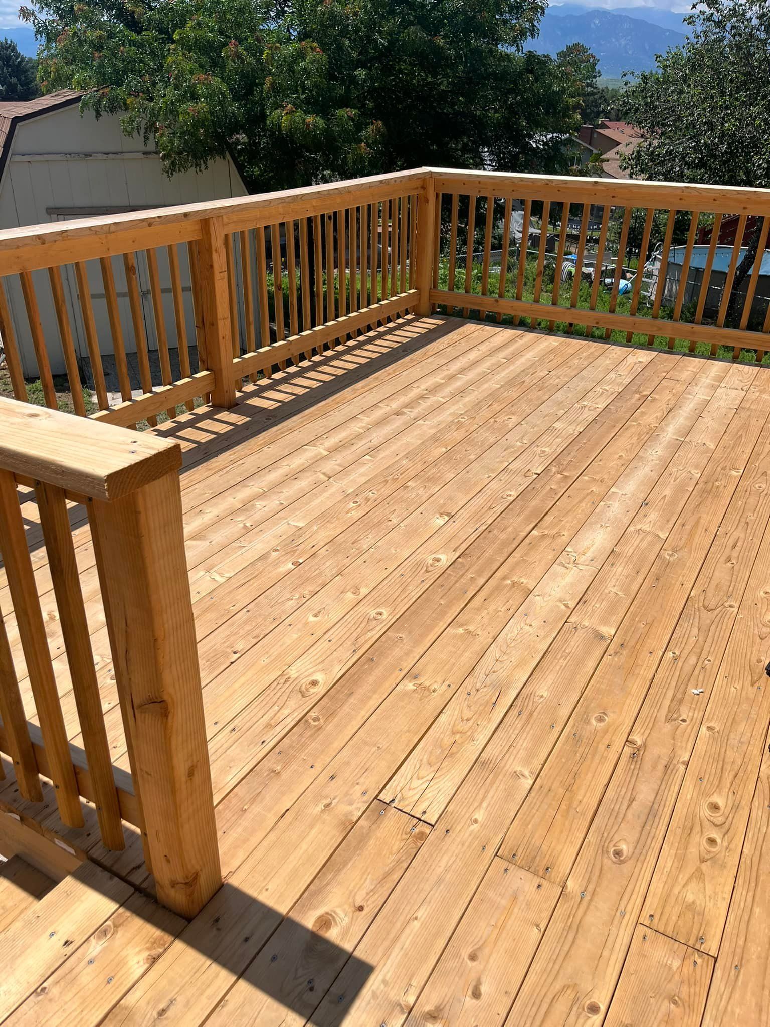 Wooden deck with railing, outdoors, sunny day.