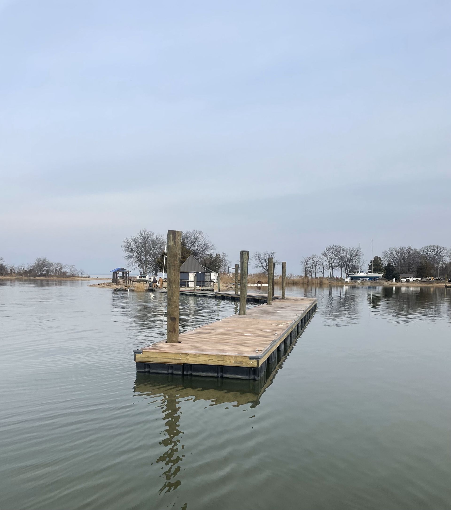 A wooden dock is floating in the middle of a lake.