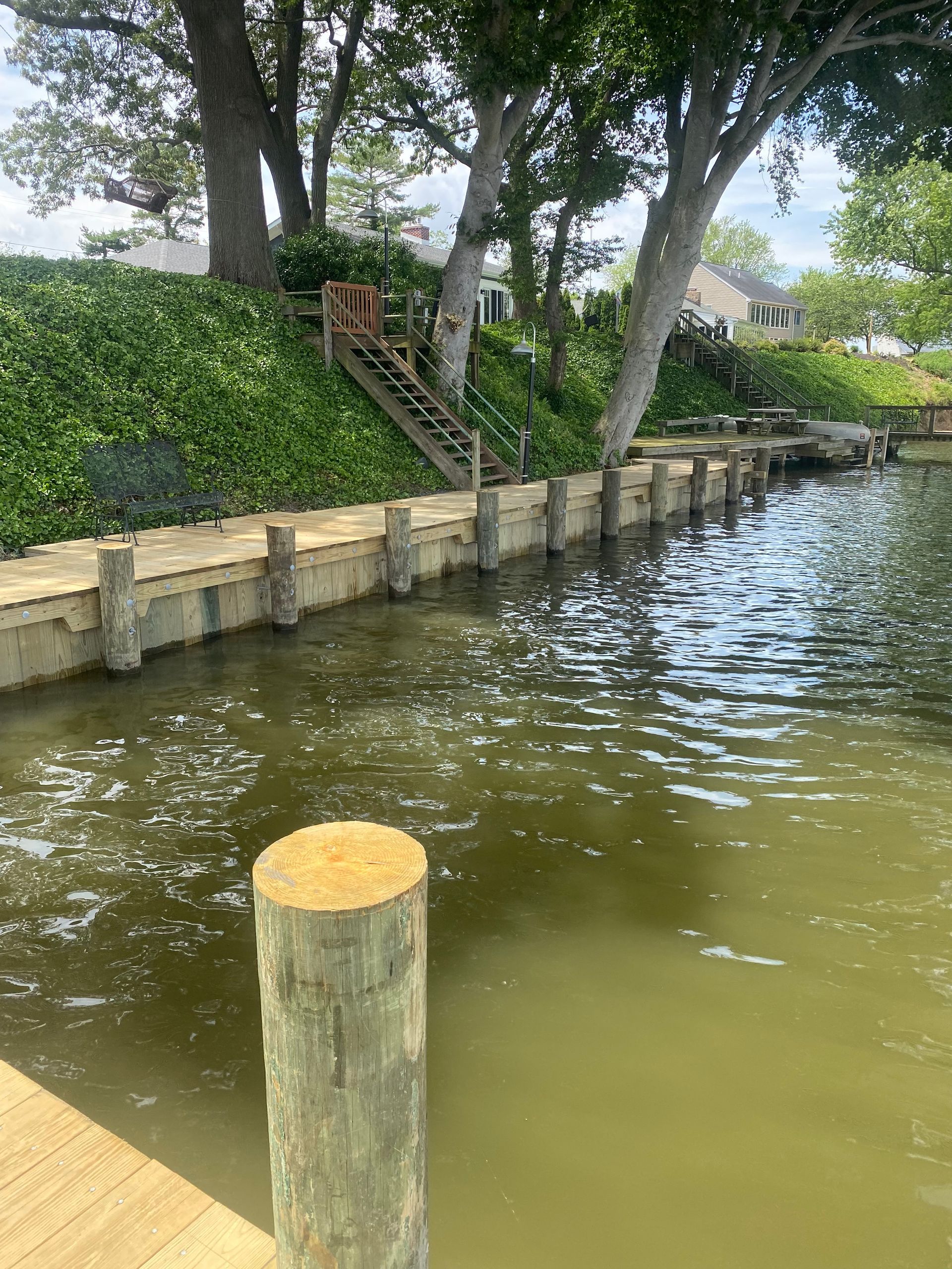 A wooden post is sitting next to a body of water.